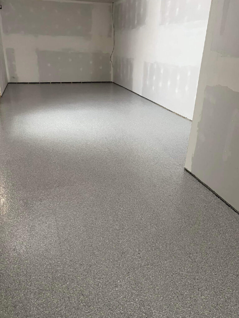 Epoxy-coated commercial interior floor in a newly constructed room with unfinished drywall