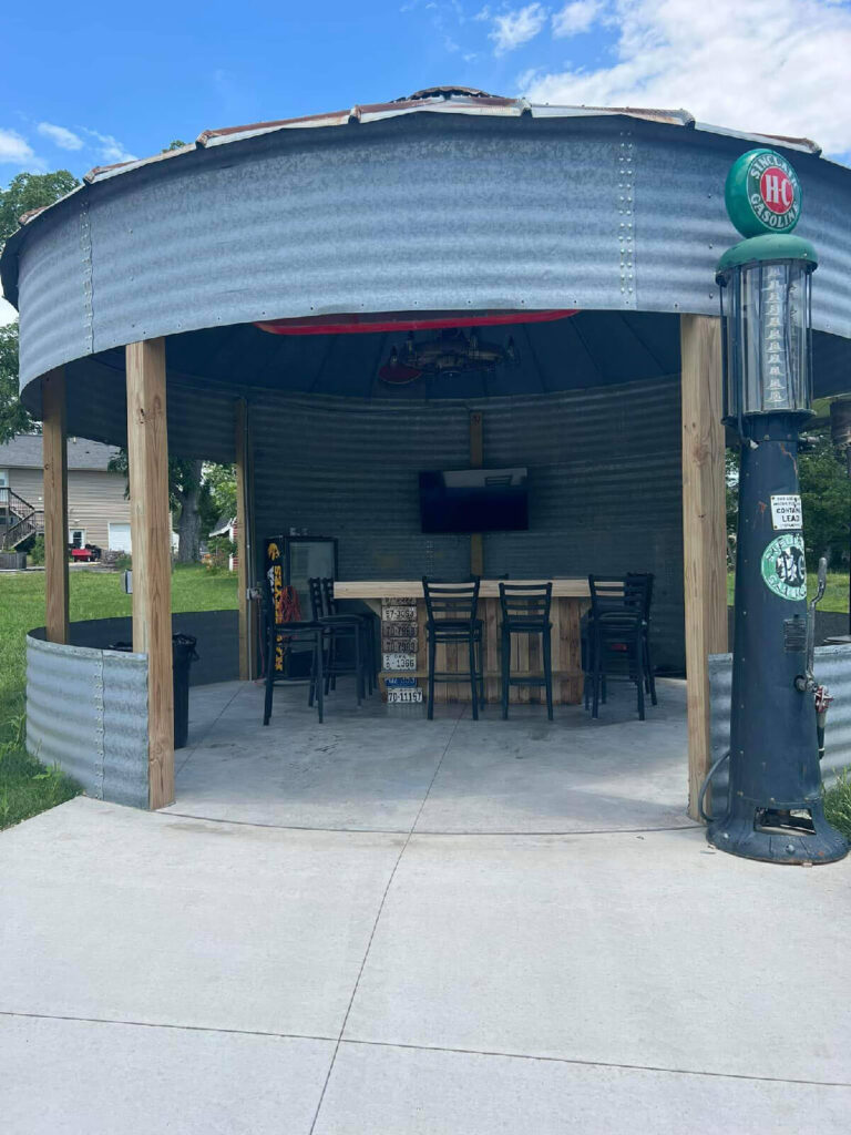Outdoor bar with epoxy-coated concrete floor and vintage gas pump decor