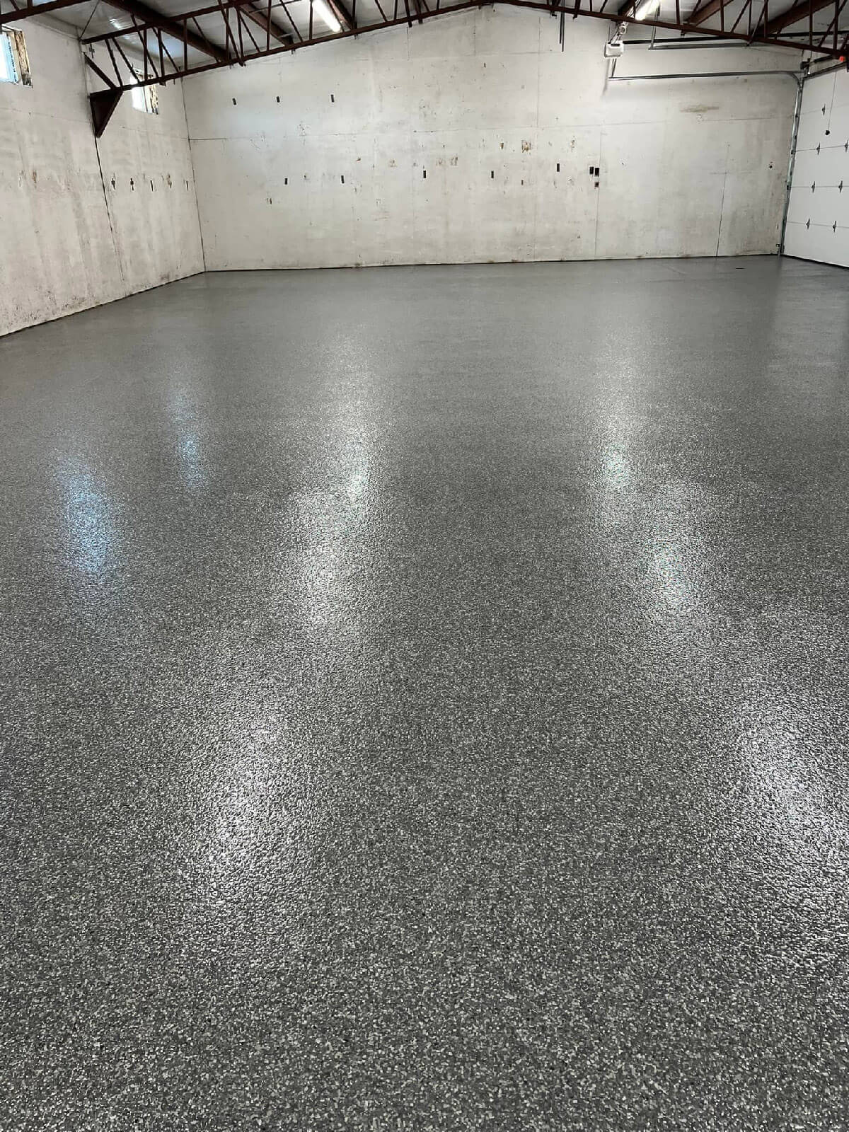 Freshly coated residential garage with seamless epoxy floor in speckled gray finish